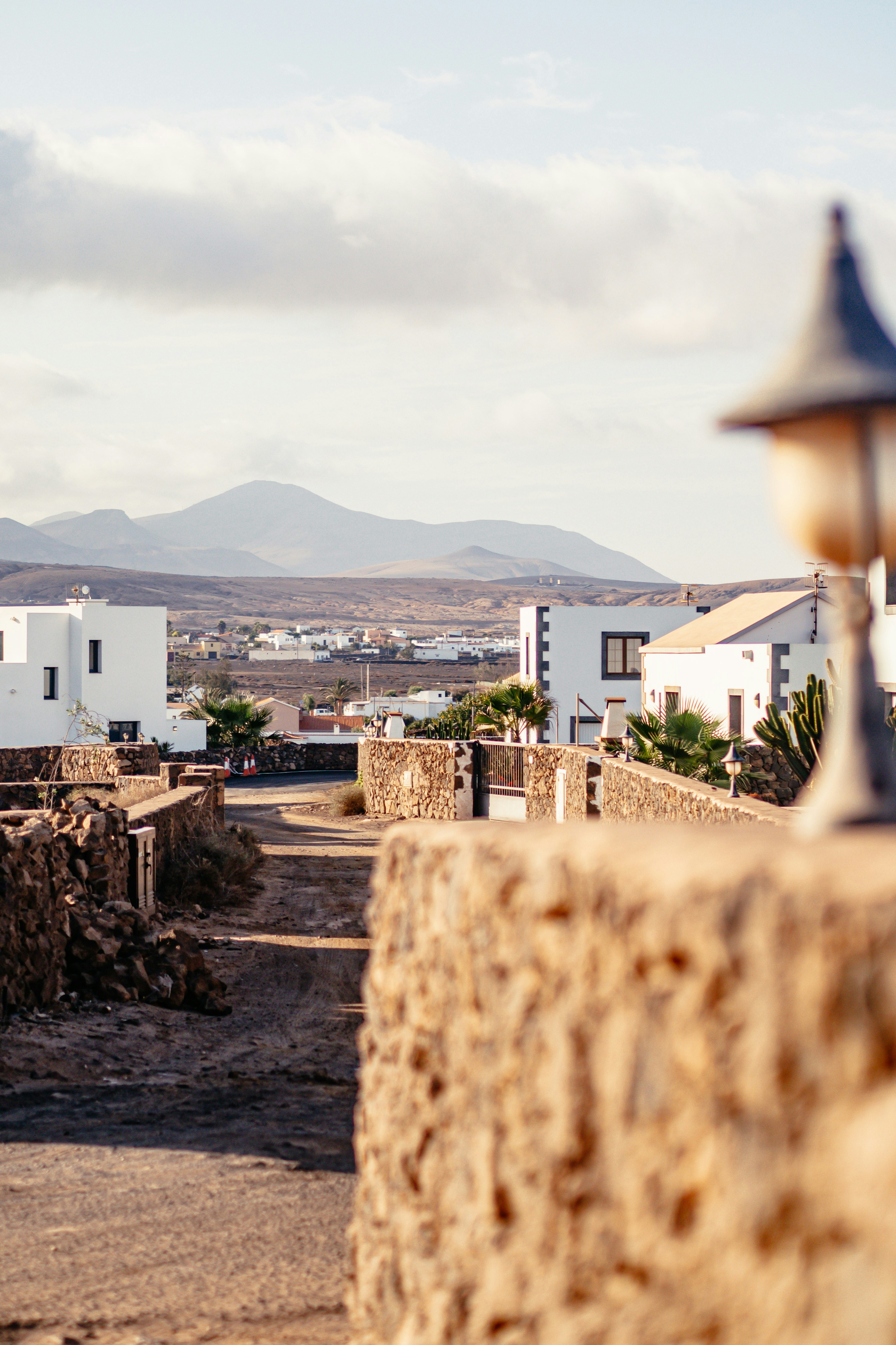 stony road of a canarian town and hills in the background