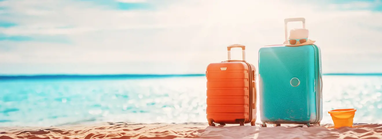 koffers op strand vakantie